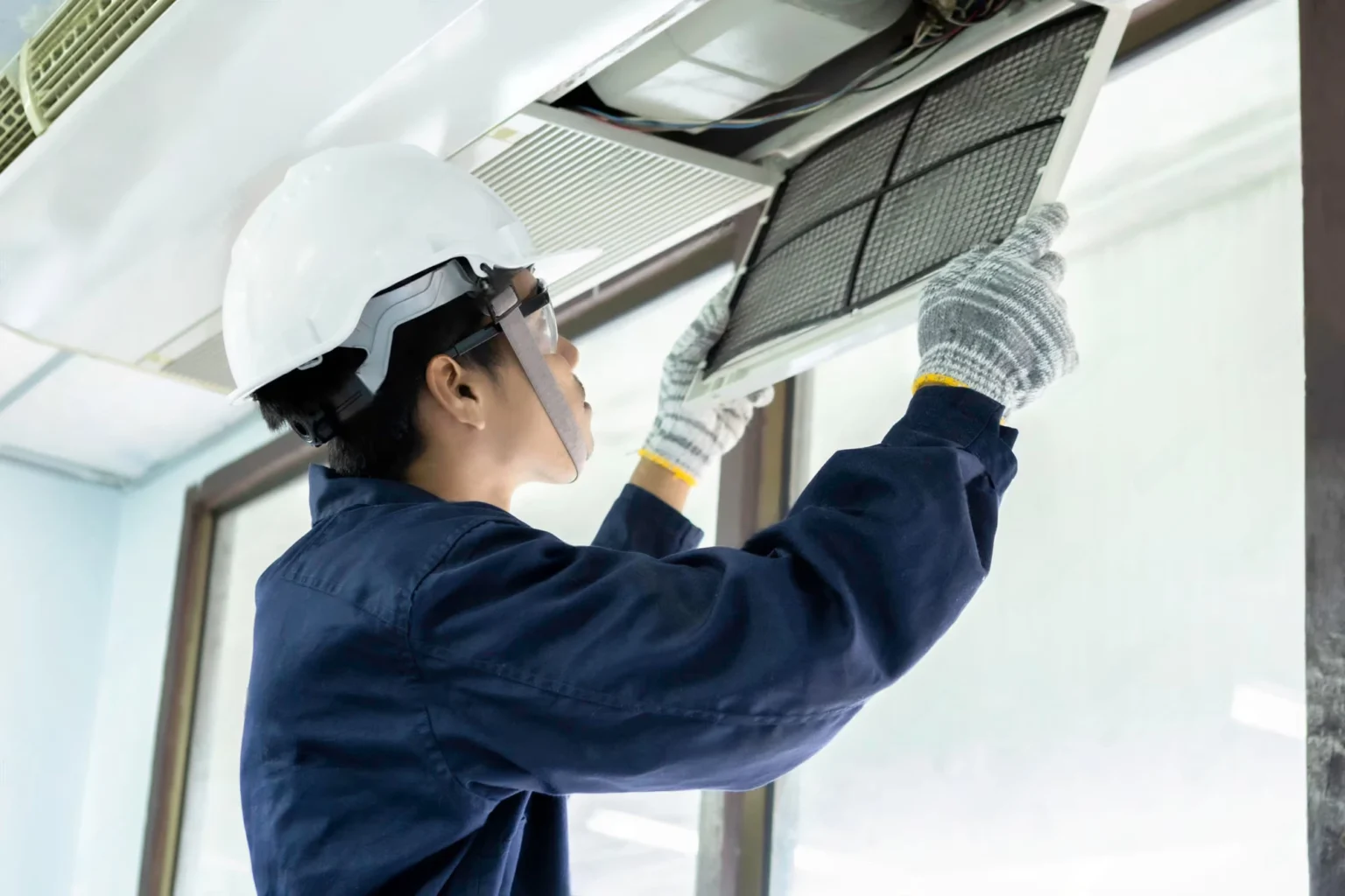 Air duct cleaning process in commercial facility using vacuum system.